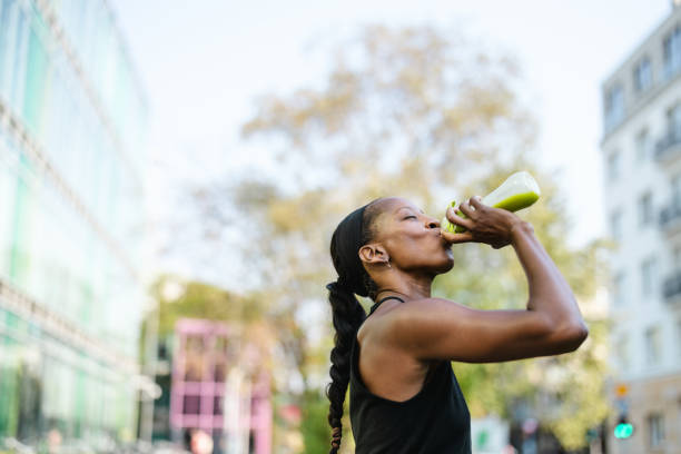 Woman drinking green smoothie after fitness running workout